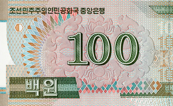 North Korean 100 won banknote featuring ornate traditional geometric patterns and denomination numerals. North Korean money.