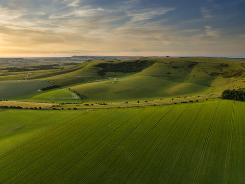 Stunning aerial drone POV landscape English countryside in colorful Summer sunrise