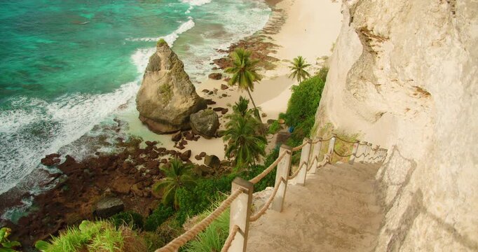 Steep stone staircase carved into a cliff leads to the shore of Diamond Beach in Nusa Penida Bali