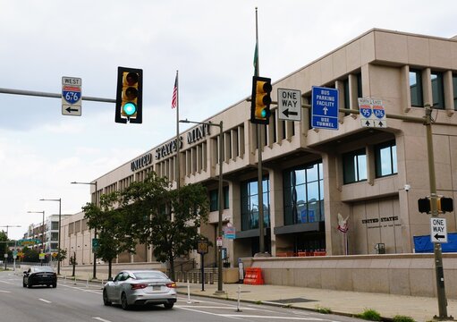 Philadelphia, Pennsylvania, U.S.A - Jul 10, 2026 - The United States Mint building viewed from a street with traffic lights and road signage.