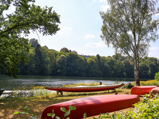 WUPPERTAL, GERMANY - JULY 25, 2026: Scenic view of Beyenburger Stausee lake with rowing boats on the riverbank and green forest in North Rhine-Westphalia. © Nadiia.