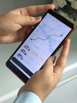 woman using smartphone to book a taxi through an app, online transportation platform, taxi service and mobile technology.