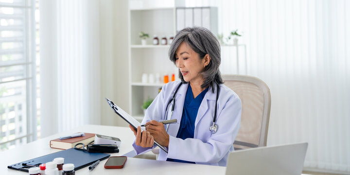 Doctor  filling paper medical records. Practitioner doing paperwork at workplace with laptop, writing notes, preparing documents, reports, prescription.