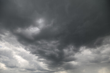Obraz premium Moody gray clouds gather ominously over the horizon during a stormy afternoon casting shadows across the landscape