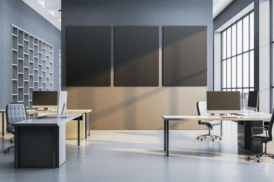 Modern corporate office interior with three blank vertical wall frames, desks, computers, shelving, and bright windows for business mockup design. 3D Rendering