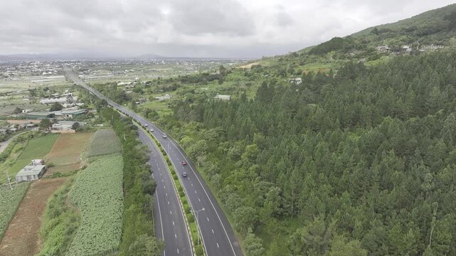 Aerial drone view of the Lien Khuong&ndash;Da Lat Expressway winding through the green mountain landscape around Nui Voi, Hiep Thanh Commune, Lam Dong Province, Vietnam.