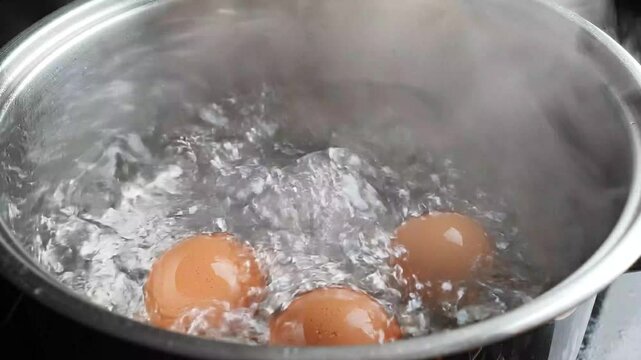Eggs Boiling in Bubbling Hot Water Inside Clear Glass Pot on Stove