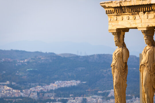 The iconic Caryatids statues of the Porch of the Maidens on the Erechtheion at the Acropolis in Athens, Greece, overlooking the city landscape.