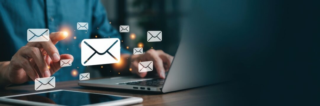 Professional using laptop for email correspondence with floating mail notifications for modern business communication.