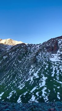 Beautiful mountain scenery at Babusar Top (Babusar Pass) in Kaghan Valley, Pakistan, featuring rugged slopes partially covered with snow beneath a clear deep blue sky.