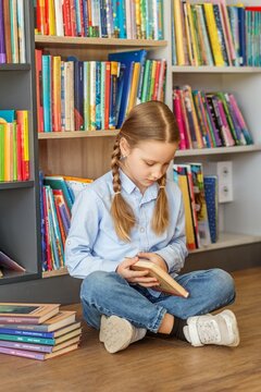 First grader reading book in library