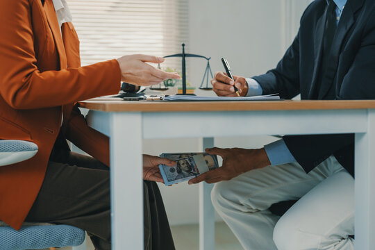 Person secretly passing money under table for bribery
