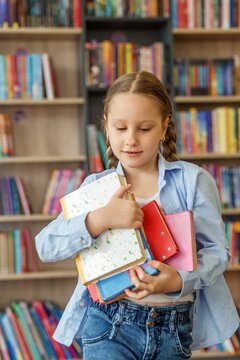 Schoolchild Choosing Books in Library