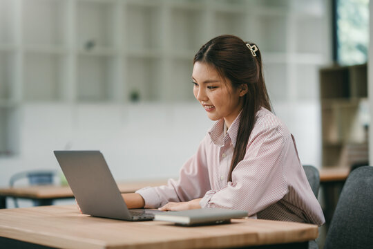 Asian woman working on laptop in modern office