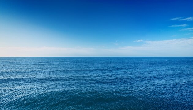 the ocean stretches out far with gentle waves rolling in the sky above is clear and bright the scene shows no land nearby only water and sky