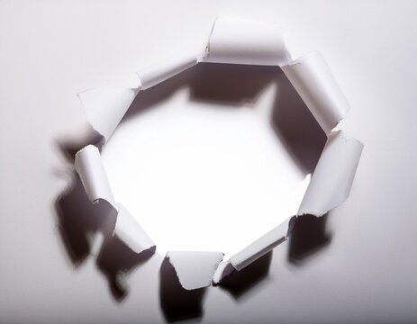 torn white paper hole with rough ripped edges and realistic shadow on white background