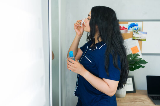 Profile of a woman removing makeup with cotton pad and skincare product, following evening beauty routine at home