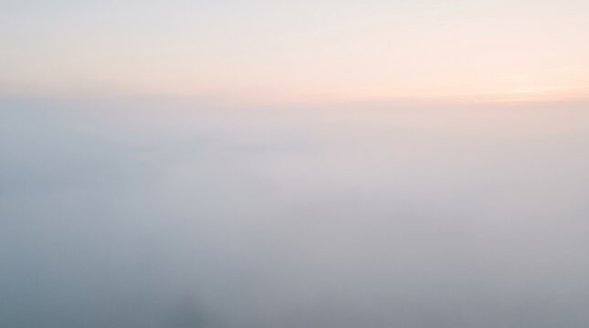 Serene morning mist rolling over peaceful landscape under soft pastel sunrise light