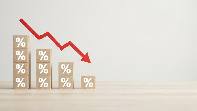 Wooden blocks arranged in a descending bar chart with percentage symbols and a large red arrow pointing downwards on a light background