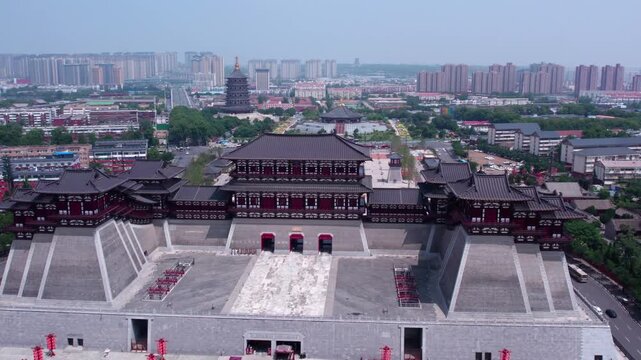 Aerial view of traditional Chinese palace architecture set in a modern urban landscape, with historic structures and open plazas.
