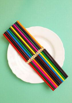 Two sets of sharpened colored pencils on a white plate