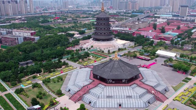 Aerial view of traditional ancient buildings and modern urban facilities in a city park area, blending historical architecture with contemporary scenery.