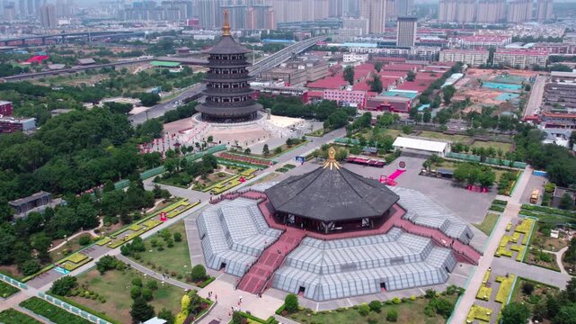 Aerial shot of a historic ancient architectural complex with two main buildings, surrounded by greenery and urban cityscape.
