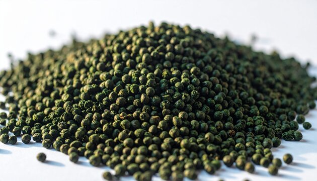 Close-up of a pile of small, dark green pellets on a white background, likely fish food