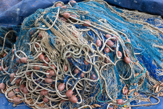 Tangled fishing nets and ropes piled on a blue tarp