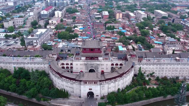An aerial shot captures an ancient city gate landmark and its surrounding mixed urban and residential area.