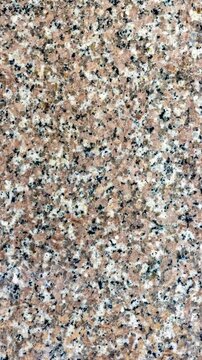 5K,Zoom in texture of polished pink granite slab with natural mineral crystals, peach terracotta hues, gray quartz deposits, and dark biotite mica speckles for commercial luxury background.Real time