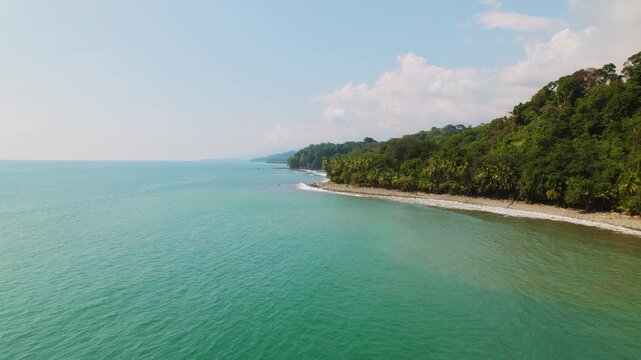 Calm turquoise ocean waves reaching the shore of Pinuelas Beach Costa Rica