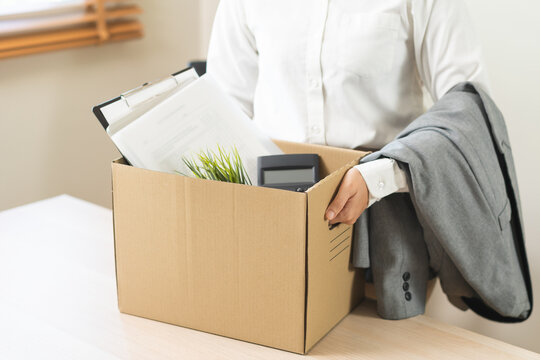 Unemployed, quite job. Desperate asian young businesswoman resigning from company, hand holding cardboard, packing belongings, stuff into box, layoff or changing work. Resignation, employment concept.