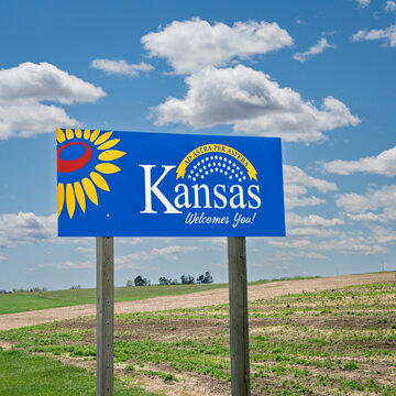 Kansas welcomes you - welcome roadside sign with a popular Latin phrase ad astra per aspera (through hardships to the stars), driving and travel concept