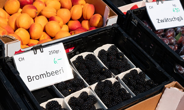 Blackberries and apricots in a crate at a market stall, Rapperswil, Switzerland, farmers market. Sweet fruit, raw food, harvest, goods, agriculture, healthy eating.