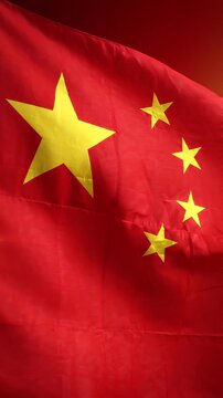 Chinese flag waving gracefully with vibrant red background, showcasing the iconic yellow stars in a dynamic flow of movement and color across the frames