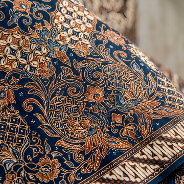 Close-up of ornate traditional Asian textile with intricate gold embroidery