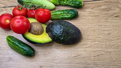 Fresh vegetable banner with avocado, tomatoes and cucumbers on wood with right copy space © Lona