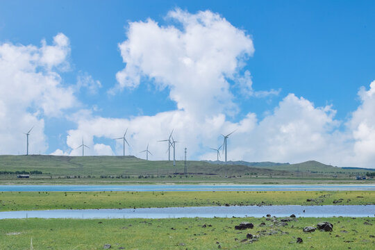 Scenic landscape of salt lake wetland and distant wind turbines in summer in Ulan Hada Volcano Geopark, Ulanqab, Inner Mongolia, China