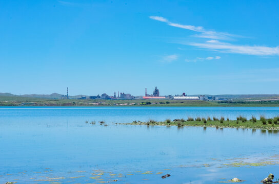 Scenic landscape of salt lake wetland and distant wind turbines in summer in Ulan Hada Volcano Geopark, Ulanqab, Inner Mongolia, China