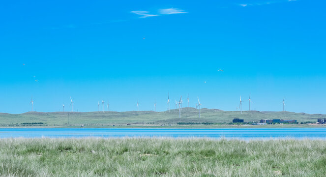 Scenic landscape of salt lake wetland and distant wind turbines in summer in Ulan Hada Volcano Geopark, Ulanqab, Inner Mongolia, China