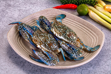Fresh blue crabs on ceramic plate with lime chili and lemongrass © Andrei Starostin