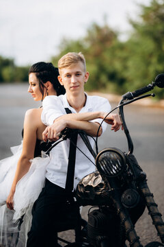 A couple of newlywed freaks on a black custom bike