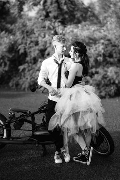 A couple of newlywed freaks on a black custom bike