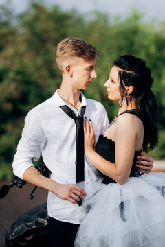 A couple of newlywed freaks on a black custom bike
