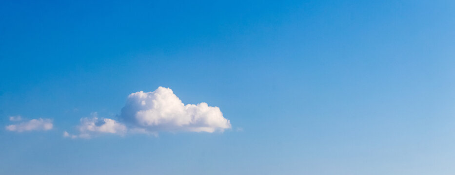 Single fluffy cloud in clear blue sky with copy space