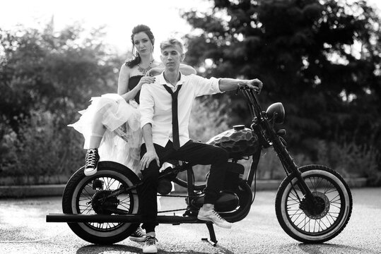A couple of newlywed freaks on a black custom bike