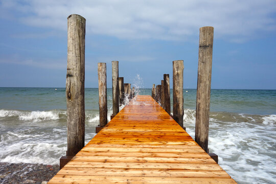 Holzsteg mit hochspritzendem Wasser