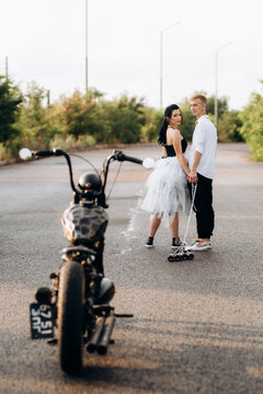 A couple of newlywed freaks on a black custom bike