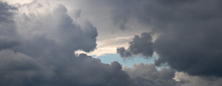 Massive storm clouds with glimpse of blue sky between them
